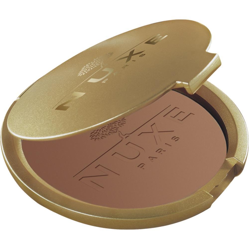 Goldene puderdose mit braunem Puder und Aufschrift "Nuxe Paris".